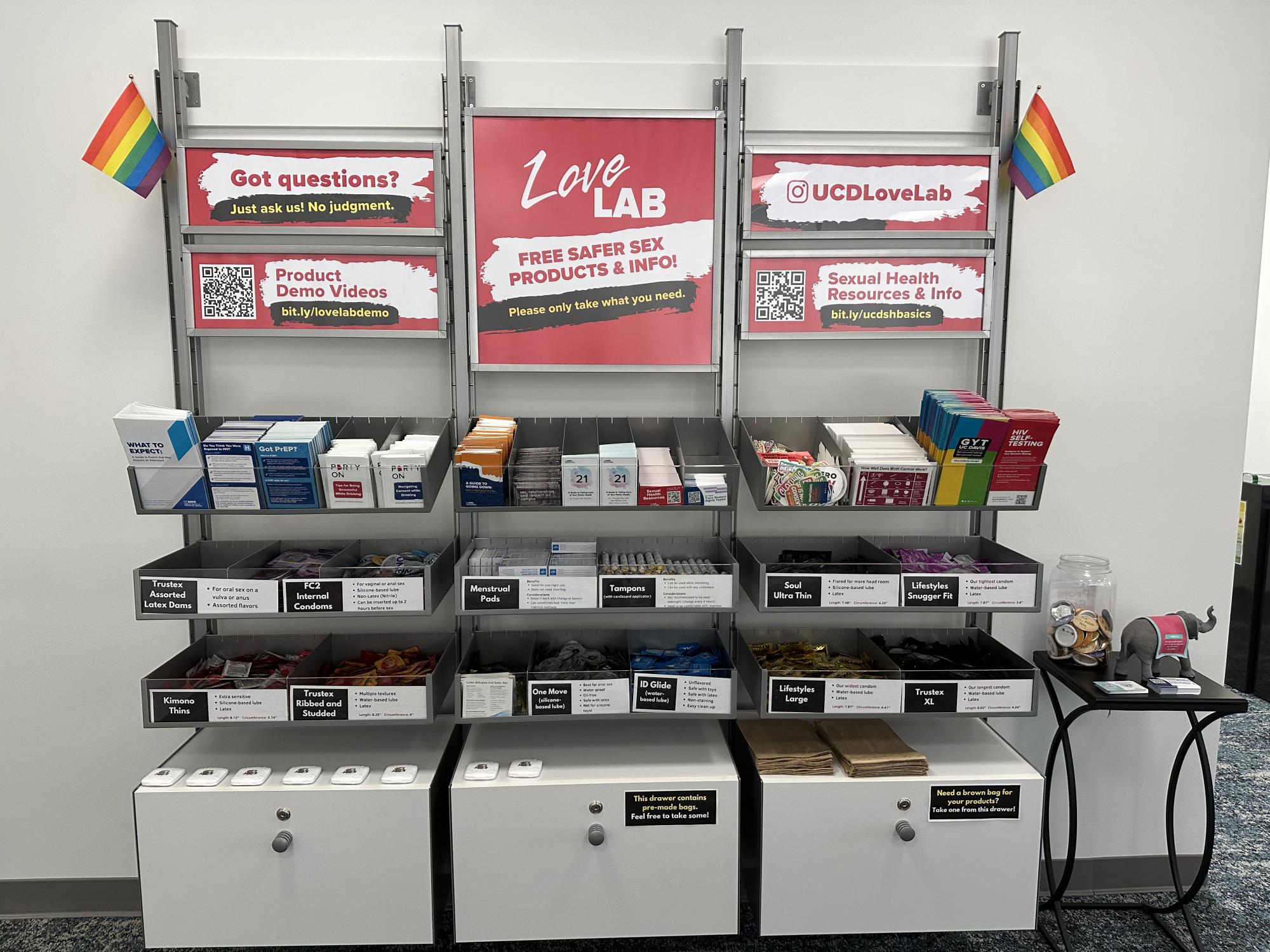 Love Lab wall display with bins of safer sex products